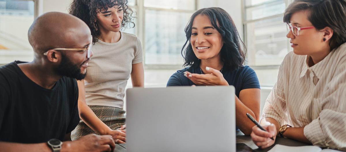 young diverse people looking at laptop