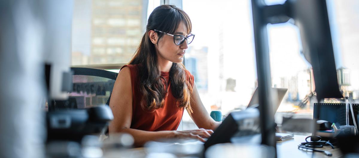 woman with glasses on laptop