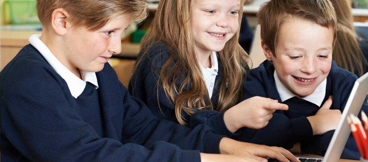 three primary school students on laptop