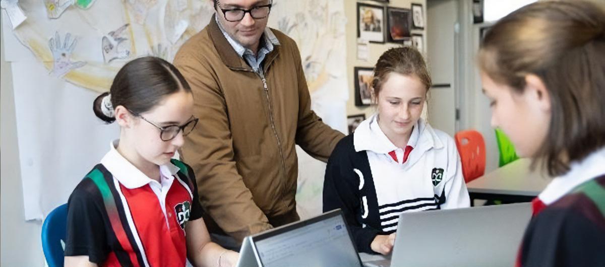 two children in class with laptops