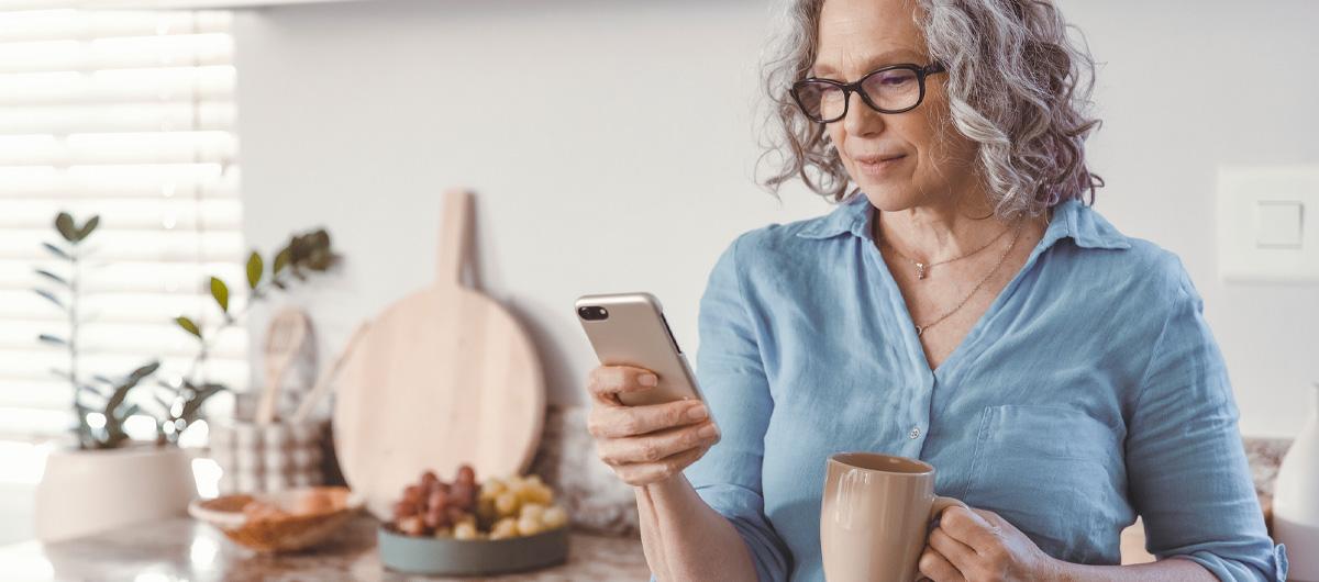 woman with grey hair on phone in kitchen