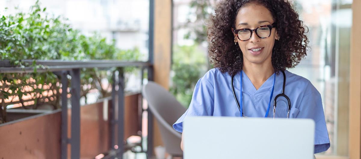 nurse on laptop with blue scrubs